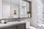 Luxe bathrooms include grey-oak vanities with marble counters, custom medicine cabinets and marble tub surround.