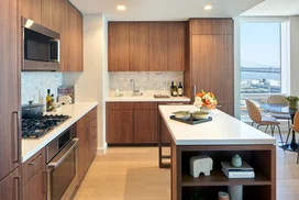 White quartz kitchen counter with a full-height Carrara marble tile backsplash