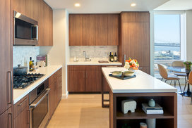 White quartz kitchen counter with a full-height Carrara marble tile backsplash