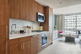 White quartz kitchen counter with a full-height Carrara marble tile backsplash