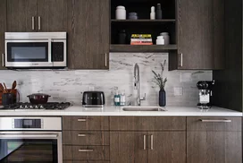 Gourmet kitchens feature gas cooktops and Bosch appliances with quartz counters and a marble backsplash.