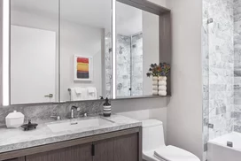 Luxe bathrooms include grey-oak vanities with marble counters, custom medicine cabinets and marble tub surround.