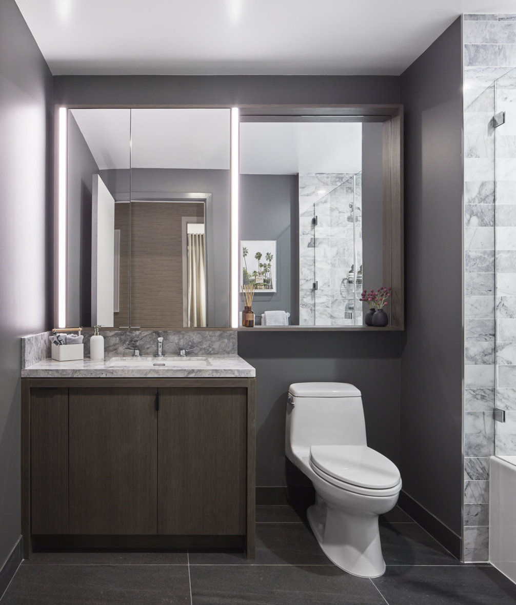 Luxe bathrooms include grey-oak vanities with marble counters, custom medicine cabinets and marble tub surround.