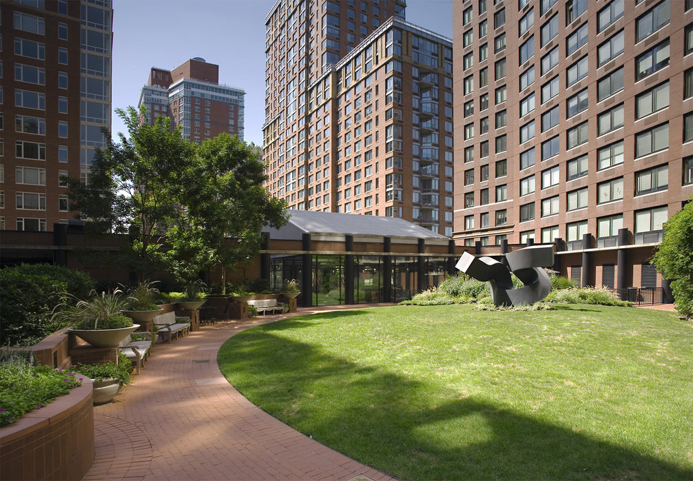 Residents relax in a lushly landscaped private garden anchored by artist Clement Meadmore's monumental steel sculpture.